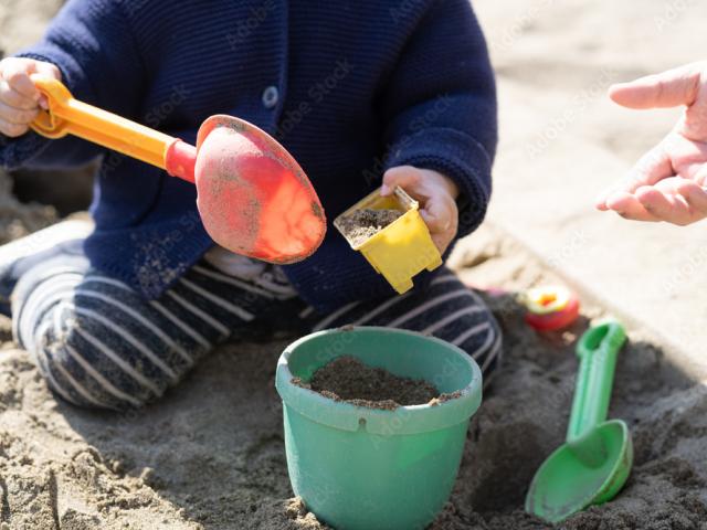 kind speelt met emmer en schep in de zandbak bij blos kinderopvang