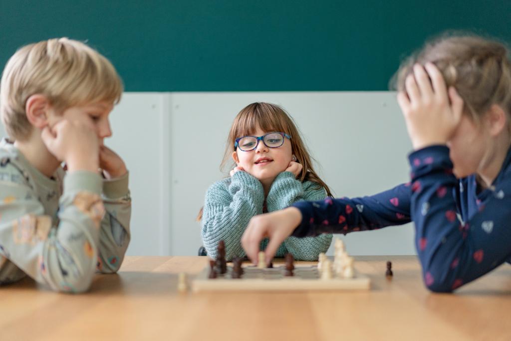 Kinderen schaken samen en meisje kijkt toe