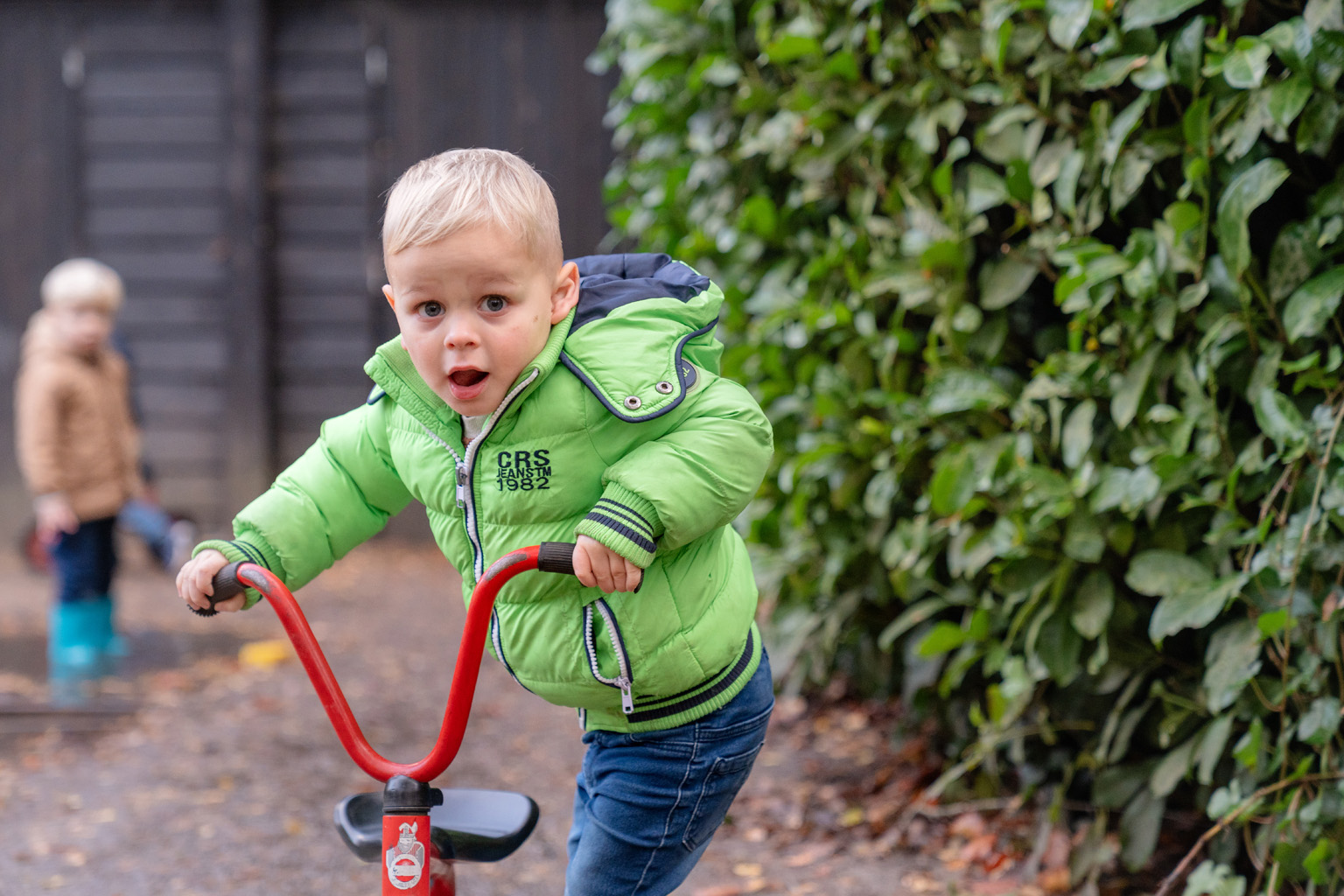 Kind stapt op rood fietsje